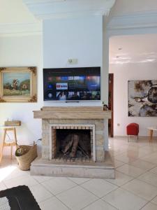 a living room with a fireplace with a flat screen tv at Villa de rêves in Casablanca