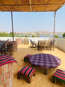 a patio with tables and chairs in the sand at Nuba Heart in Aswan