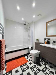 a bathroom with a tub and a toilet and a sink at Beautiful Hatfield 2 Bedroom Apartment FREE Gated Parking - Modern Stylish - Business Park, Hertforshire University, St Albans, Welwyn Garden City, Luton Airport, Harry Potter Studio Tour in Hatfield