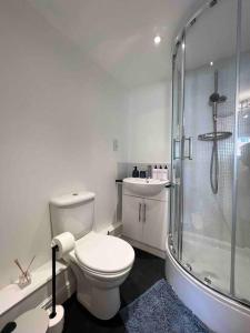 a white bathroom with a toilet and a shower at Beautiful Hatfield 2 Bedroom Apartment FREE Gated Parking - Modern Stylish - Business Park, Hertforshire University, St Albans, Welwyn Garden City, Luton Airport, Harry Potter Studio Tour in Hatfield