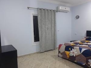 1 dormitorio con cama y ventana en Sun, Sea & Comfort en Hurghada