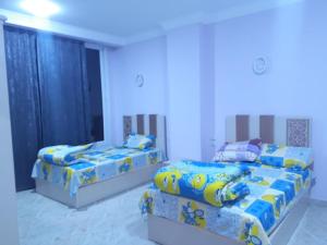 2 camas en una habitación con paredes azules en Sun, Sea & Comfort en Hurghada
