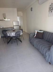 - un salon avec un canapé et une table dans l'établissement Sunquest court, à San Pawl il-Baħar