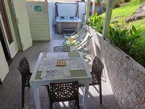 una mesa y sillas en un patio con fregadero en Villa CANA - Appartement 2 chambres avec SPA privatif en Terre-de-Haut