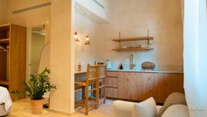 a kitchen with a counter and chairs in a room at Hagafen Boutique Suites in Zikhron Ya'akov