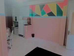 une cuisine avec une peinture colorée sur le mur dans l'établissement Hostel Leonardo 10 Estrelas, à Vitória