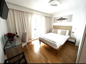 1 dormitorio con 1 cama y escritorio con TV en Naturhotel Wieserhof, en Longostagno