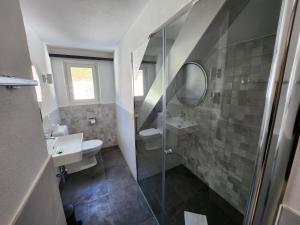 a bathroom with a shower and a sink and a toilet at Hotel Bergsonne Rigi in Rigi Kaltbad