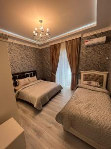 a bedroom with two beds and a chandelier at Qabala Joy Villa in Gabala