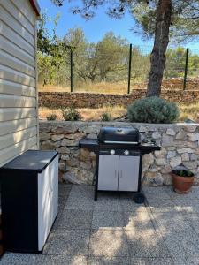 a barbecue grill sitting next to a stone wall at Mobile home "Sun" Jezera Village , otok Murter in Jezera