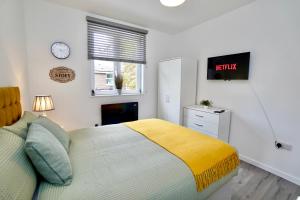 1 dormitorio con 1 cama y reloj en la pared en Luxury Flats in Southsea Portsmouth, en Portsmouth