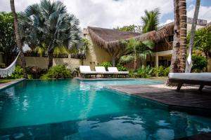 a swimming pool in front of a house with palm trees at Casa Elea in Jericoacoara