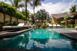 a swimming pool with a hammock and palm trees at Casa Elea in Jericoacoara