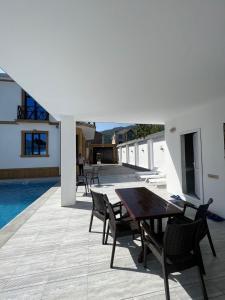 a patio with a table and chairs next to a pool at Qabala Joy Villa in Gabala