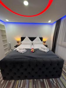 a bedroom with a large black bed with two towels at Modern Apartments Neuburg 3 - TOP NEU - 2 Zimmer, Komfort, Balkon, Wi-Fi, Smart TV, Badewanne, Küche in Neuburg an der Donau