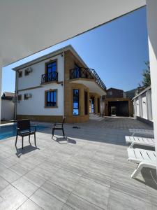 a large patio with two chairs and a building at Qabala Joy Villa in Gabala