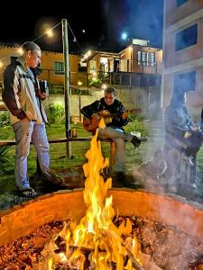 a group of people standing around a fire at Casa Amantes da Serra Ibitipoca - Satisfação Garantida in Conceição da Ibitipoca