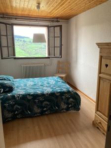 um quarto com uma cama e uma janela em Les Pâturages em La Bresse