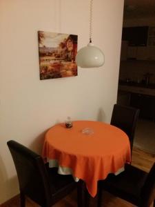 a dining room table with a orange table cloth on it at Sweet Apartment in Belgrade