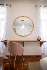a dressing table with a mirror and a chair at Apeiron Acropolis Suites in Athens