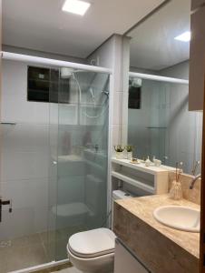 a bathroom with a shower and a toilet and a sink at Apartamento Alto da Serra Villas in Bananeiras