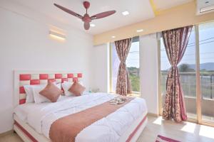 a bedroom with a large bed and a large window at shubh villa 4bhk in Lonavala