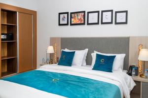 1 dormitorio con 1 cama grande con almohadas azules en Hotel Golden Sunset Dakhla, en Dakhla