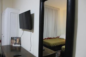 einen Spiegel in einem Zimmer mit einem Bett und einem TV in der Unterkunft Anas Hostel in Wadi Musa