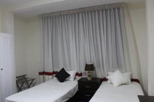 2 Betten in einem Hotelzimmer mit Fenster in der Unterkunft Anas Hostel in Wadi Musa