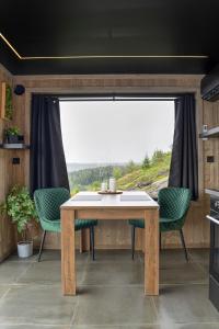 einen Tisch und Stühle in einer Küche mit einem großen Fenster in der Unterkunft Hide Hut - Amazing view 50 min from Oslo in Stange + 29 Fotos