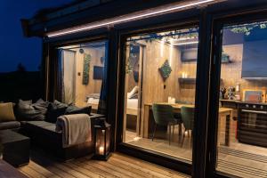 een kamer met een balkon, een bank en een tafel bij Hide Hut - Amazing view 50 min from Oslo in Stange