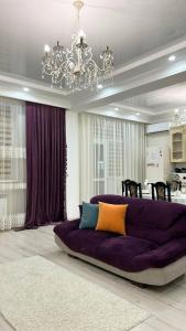 ein großes lila Sofa im Wohnzimmer in der Unterkunft Двухкомнатные апартаменты в золотом квадрате ЖК GREEN PLAZA in Aqtau