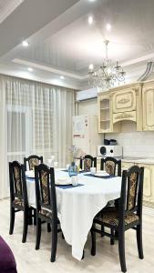 ein Esszimmer mit einem weißen Tisch und Stühlen in der Unterkunft Двухкомнатные апартаменты в золотом квадрате ЖК GREEN PLAZA in Aqtau