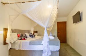 a bedroom with a bed with a canopy at Pousada Imperador do Espelho in Praia do Espelho +117 photos