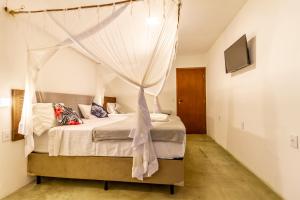 ein Schlafzimmer mit einem Himmelbett in der Unterkunft Pousada Imperador do Espelho in Praia do Espelho