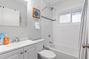 a white bathroom with a toilet and a sink at The Bamboo House! Dog-Friendly Home n RVA Sleeps 8 in Richmond
