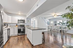 a kitchen and dining room with white cabinets and a table at The Bamboo House! Dog-Friendly Home n RVA Sleeps 8 in Richmond