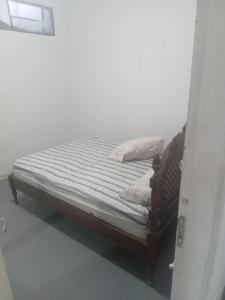 Cama pequeña en habitación con en Hostel Leonardo Quarto com cama de casal, en Vitória