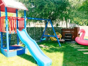 a playground with a slide and a swing at Holiday Home in Kashubia with Pool & Sauna in Częstkowo