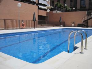 duży basen z niebieską wodą w obiekcie Apartamento Las Rozas Village w mieście Las Rozas de Madrid