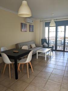 a living room with a couch and a table and chairs at APARTAMENTO EN COTO DE SANCTI PETRI in Chiclana de la Frontera