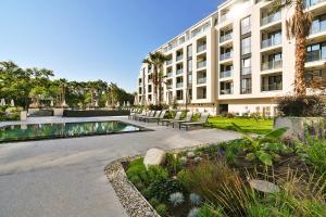 un edificio con piscina frente a un edificio en The Shangri-LA flat en Saints Constantine and Helena