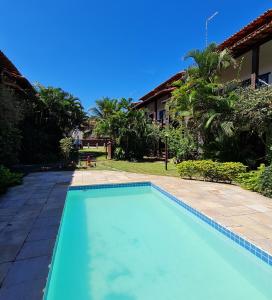a swimming pool in front of a house at Casa no Peró - Orla Azul in Cabo Frio