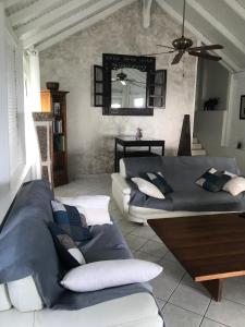 a living room with two couches and a mirror at Villa Ti Kay Long in Les Trois-Îlets