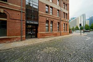 a brick building with a sign on it on a street at Spacious 2 bedroom city centre apartment in Leeds
