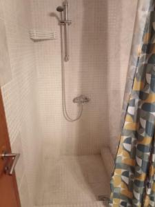 a shower with a shower curtain in a bathroom at To Spitaki 