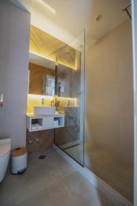 a bathroom with a glass shower and a sink at Ritsa Resort in Ureki