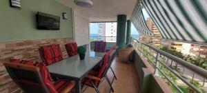 ein Esszimmer mit Tisch und Stühlen auf einem Balkon in der Unterkunft Apartamento en urbanización lujo in Tavernes de la Valldigna