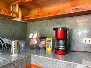 Una cafetera roja sentada en un mostrador en una cocina en Cozy Studio Apartment with Free Parking en Bayombong