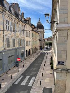 an empty street in a city with buildings at Appartement La Tour in Vesoul +4 photos
